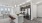 A bright, white open apartment floorplan featuring a kitchen with dark wood cabinetry in an apartment near Keller TX.