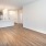 A living room with the view of a kitchen with modern wood cabinetry in an apartment in Fort Worth.