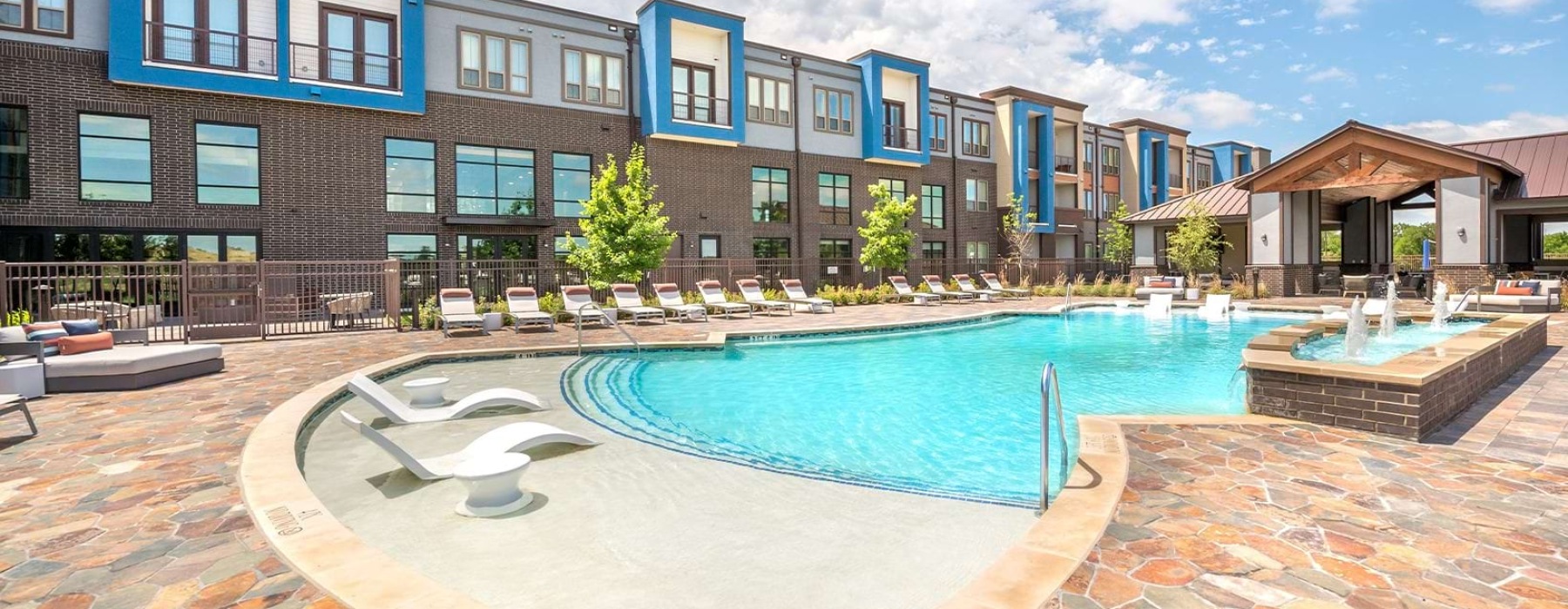 Large sparkling pool with lounge chairs and fountain