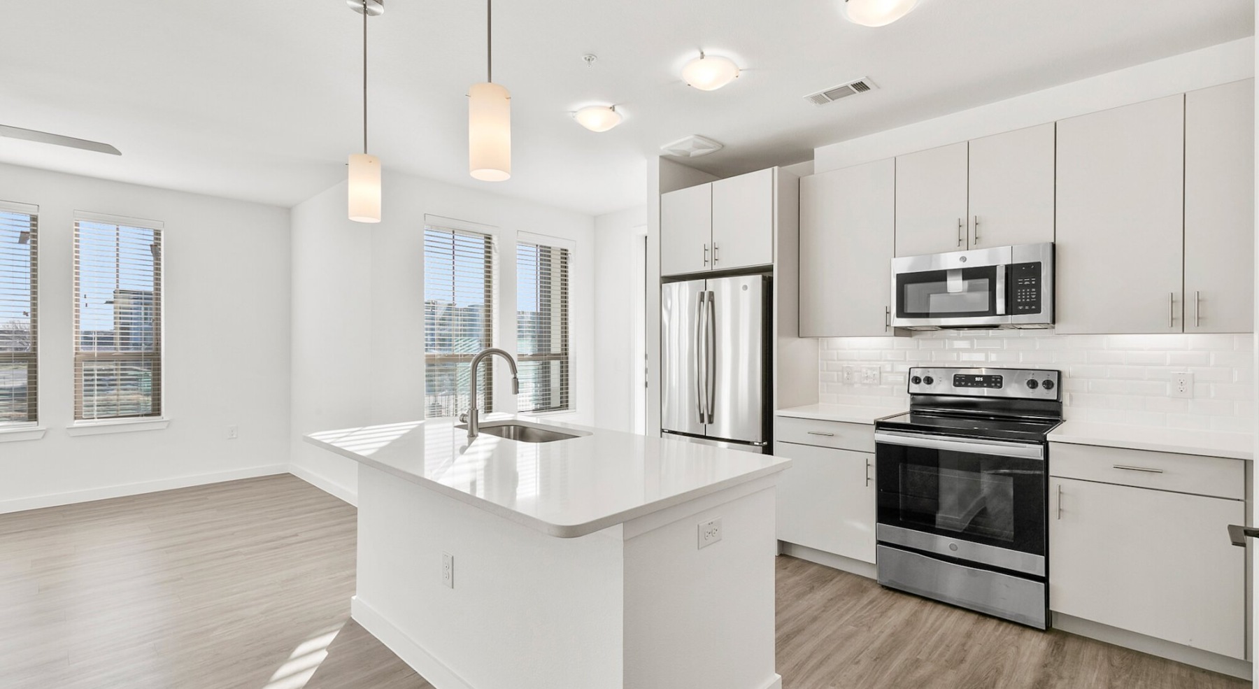 a kitchen with white cabinets and white quartz counter tops